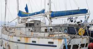Embarcaciones y personal de Salvamento Marítimo proceden al reflote de una embarcación hundida en el puerto de Aguilas.