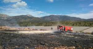 Bomberos del CEIS y agente medioambiental apagan una quema de plásticos junto al monte, en Aledo.